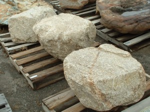 Photo of Golden Granite Boulder. Use in landscaping. Natural stone sold by Rolleri Landscape Products.