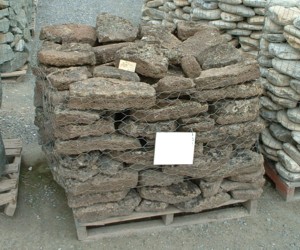 Photo of Flat Moss Rock. A flat porous lava rock with lichen and moss with square edges. Use for Wall Cap Stone, Drystack stone wall, Masonry Stone Wall, and Water feature. Natural stone sold by Rolleri Landscape Products.