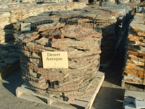 Photo of Desert Antique Moss Rock. A flat stone with lichen and moss. Use for Wall Cap Stone, Drystack stone wall, Masonry Stone Wall, Water feature, and Pond. Natural stone sold by Rolleri Landscape Products.